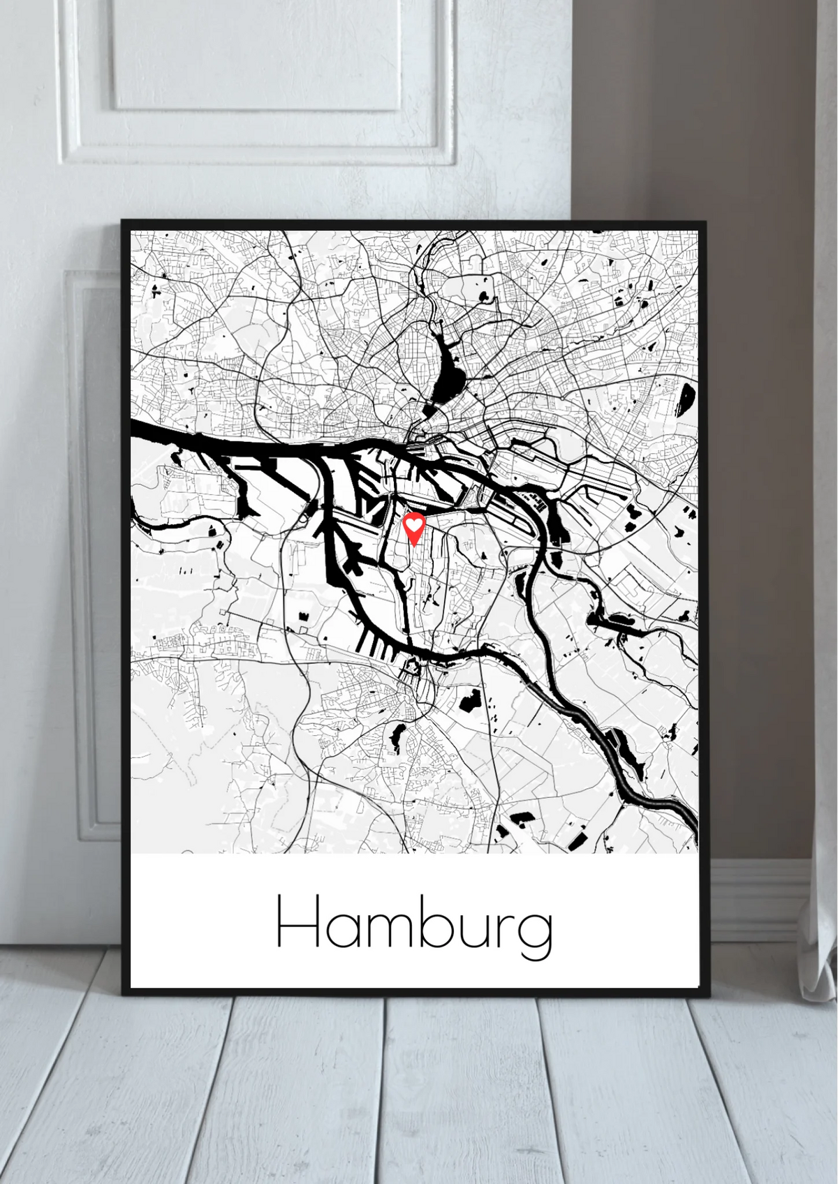 Stadtkarten Poster personalisiert – Stadtplan mit Herz-Markierung und Stadtname, im schwarzen Rahmen angelehnt