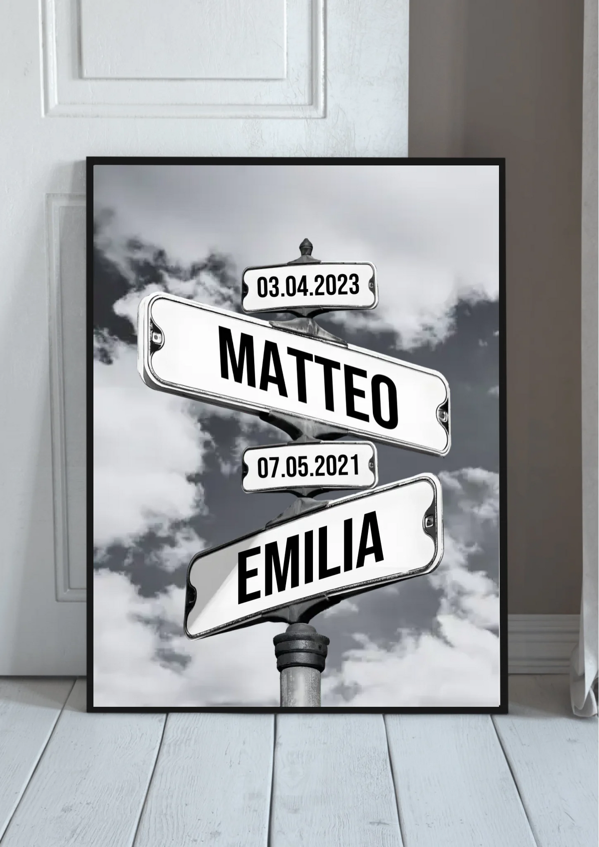 Familien Straßenschilder Poster personalisiert – Wegweiser mit Namen vor Wolkenhimmel, im schwarzen Rahmen angelehnt