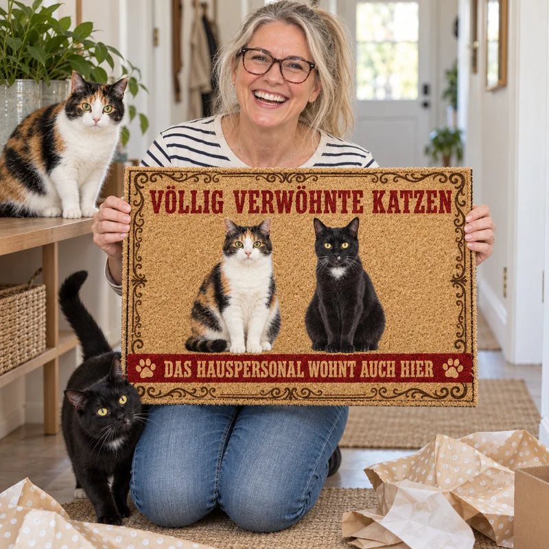 Frau hält personalisierte Katzen-Fußmatte, Katzen daneben